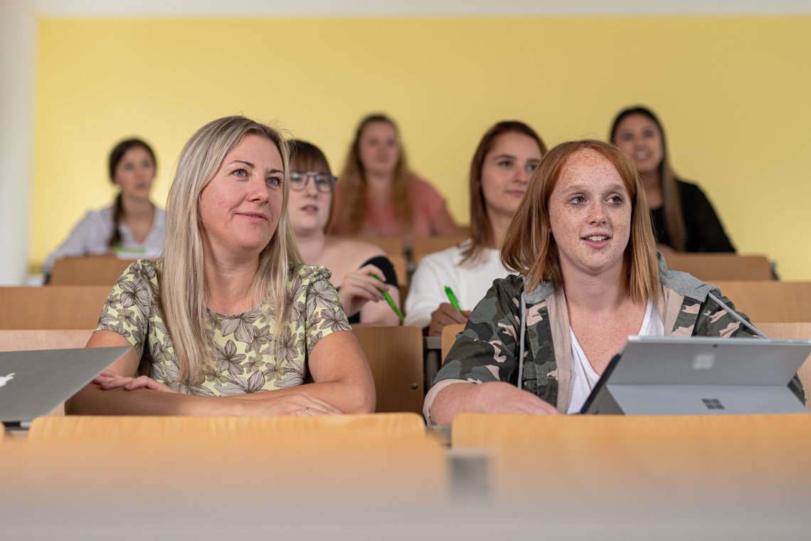 Gruppe von mehreren Schülern sitzt im Hörsaal